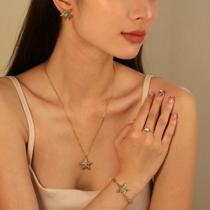 Golden starfish jewelry set with turquoise stones featuring necklace, bracelet and shell ring