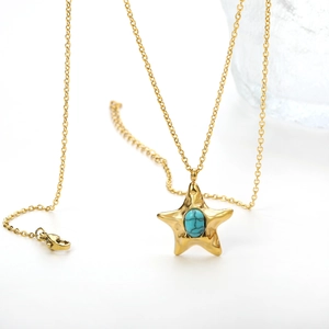Macro view of starfish pendant necklace with turquoise stone and golden metal chain