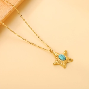 Detail of gold chain necklace with star pendant featuring an inlaid blue natural stone