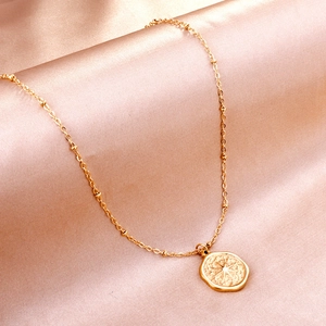 Vintage 18K gold plated compass star coin necklace on elegant champagne silk fabric