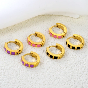 Detail of gold plated huggie hoops with colorful enamel checkerboard patterns