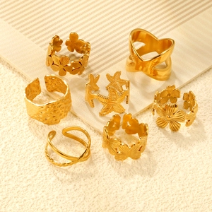 Collection de bagues dorées à fleurs et étoiles de mer sur surface texturée