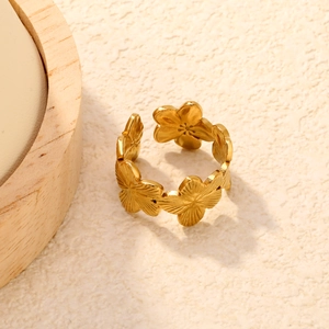 Détail d'une bague fleur dorée avec textures de pétales et anneau ajustable ouvert