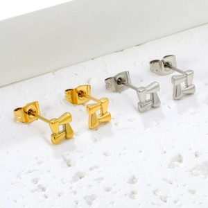 Polished stainless steel geometric star earrings in gold and silver on white pedestal
