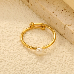 Minimalist 18K gold stainless steel open ring with a round pearl on a stone background