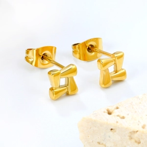 Macro detail of gold geometric square stud earrings made of polished stainless steel