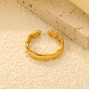 Gros plan d'une bague ajustable dorée avec motif matelassé sur fond élégant