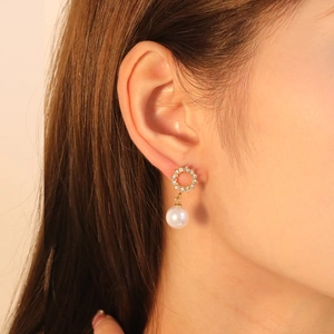 Elegant French luxury pearl drop earrings with sparkling zircon studs on female model
