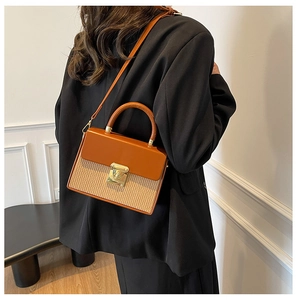 Chic box bag with orange leather flap and beige textured body shown on a model