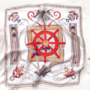 Flat lay macro view of square silk scarf with nautical ship wheel and anchor print