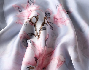 Detailed close-up of premium silk scarf featuring elegant pink magnolia floral prints