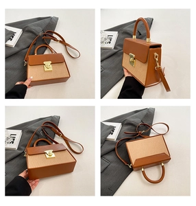 Detail view of brown leather and woven fabric crossbody bag with golden rotary clasp