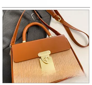 Detail shot of vintage contrast box bag with golden metal square rotary lock and handle