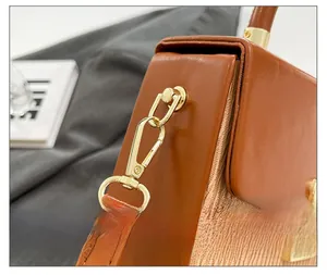 Close-up of premium gold hardware and precise stitching on the brown leather box bag