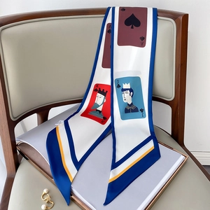 Detailaufnahme des Twilly-Schals mit Spielkarten-Print auf einem Stuhl mit Perlen