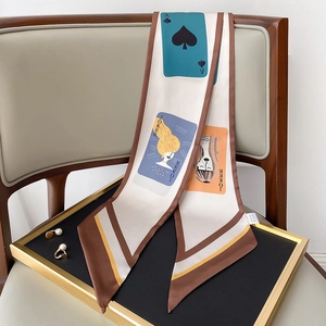 Detailansicht eines Seidenschals mit Spielkartenmotiven und geometrischen Streifen