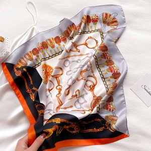 Carré en satin de soie avec imprimé chaînes et glands élégamment drapé sur tissu blanc
