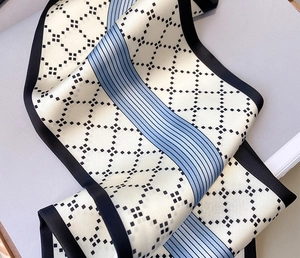 Détail d'un foulard en soie à motif losange avec rayures bleues et fini satiné
