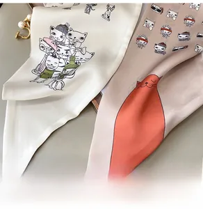 Detail shot of silk scarf fabric showing cute cat illustrations and smooth texture