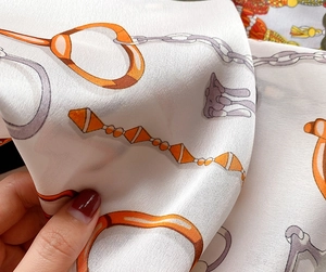 Détail macro de l'imprimé chaîne équestre de luxe sur tissu soyeux et lisse de foulard
