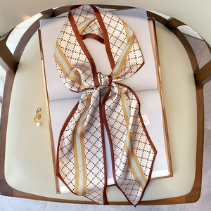 Écharpe étroite en soie à motifs géométriques marron et jaune nouée en ruban