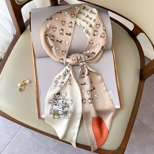 Champagne cat print skinny silk scarf tied in a bow on a magazine backdrop