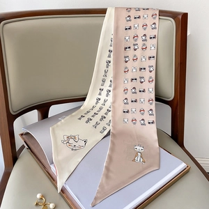 Detailed macro of two elegant long narrow twilly scarves with cute cartoon cat illustrations