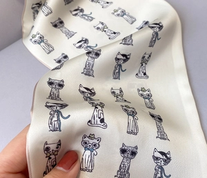 Detail shot of silk texture scarf with cute cartoon cat prints and fine edge stitching