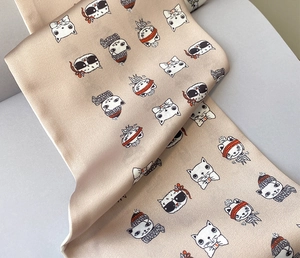 Detail of silk texture scarf with cute cartoon cat prints and champagne glossy finish