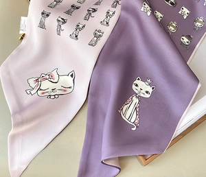 Detailed macro shot of printed silk scarf with cute cartoon cat patterns and satin texture