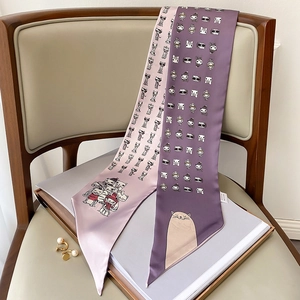Detail of satin twilly scarves with cute cartoon cat prints on a magazine and chair