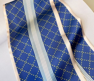 Gros plan d'un foulard en soie au motif de losanges bleus et texture satinée luxueuse