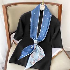 Narrow silk scarf featuring blue polka dots and rabbit prints on a black knit top