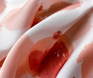 Détail macro d'un foulard en satin de soie avec motifs de points aquarelle orange-rose