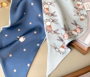 Detail of 100% silk feel scarf with elegant polka dots and modern origami rabbit print