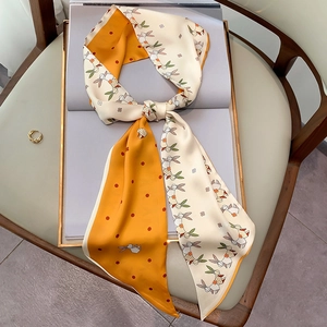 Detailed view of double-sided silk scarf with rabbit pattern and golden ring accessory