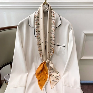 Close-up of a floral rabbit print silk scarf tied elegantly around a pajama collar