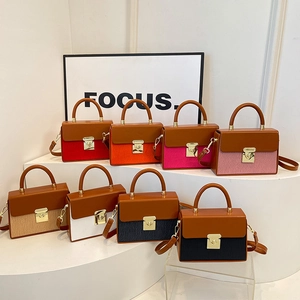 Modern two-tone crossbody bags in multiple colors with metallic turn-lock and top handle