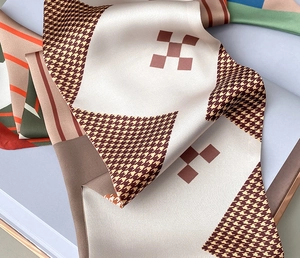 Close-up of elegant silk-satin scarf featuring houndstooth and geometric prints