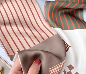 Detail view of silky patterned scarf featuring houndstooth and stripes with elegant luster