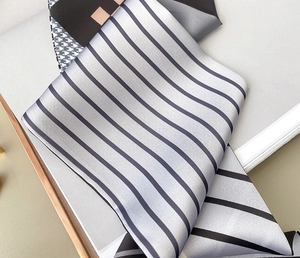 Detailed view of silver grey striped silk scarf with orange and houndstooth pattern