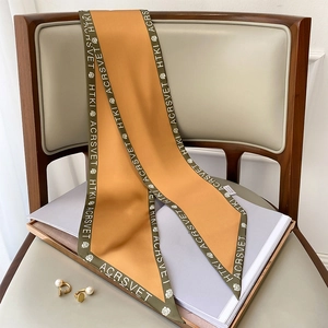 Dettaglio macro di un foulard in raso di seta con stampa di lettere e stile retrò