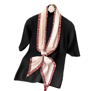 Sciarpa di seta rosa stampata con camelia su top in maglia nera elegante
