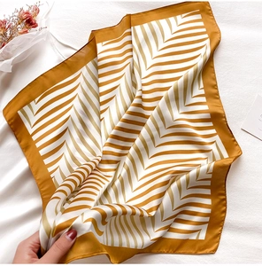 Detailed view of yellow and white herringbone silk scarf showing soft drape and texture