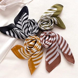 Detail of four striped silk scarves in green, black, yellow and brown silk material