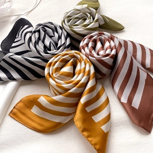 Detail of silk-feel scarves with geometric patterns rolled into decorative shapes