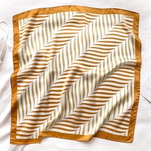 Close-up of elegant yellow and white chevron silk scarf with polished satin finish texture