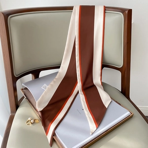Detailansicht eines gestreiften Satin-Seidenschals für Haare oder Taschen am Stuhl