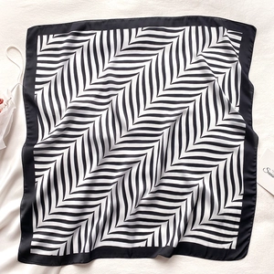 Close-up of elegant black and white herringbone silk scarf with a wide black border