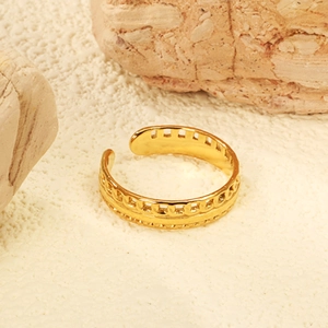 Macro shot of 18K gold plated stainless steel open ring with carved chain patterns